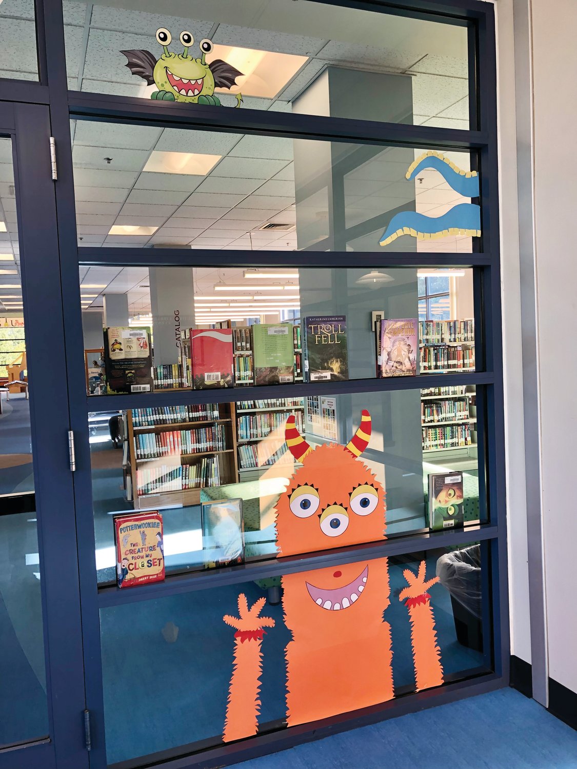 Friendly monsters of different colors, shapes, and sizes offer their welcome to the children’s department at the Warwick Library.